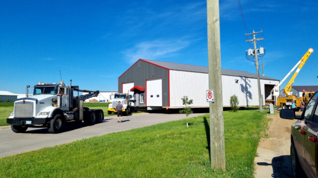 um die Kurve zu kriegen, muss der Fahrer auf die Wiese fahren, steckt dort fest und wird von einem bereitstehendem Abschleppfahrzeug raus gezogen