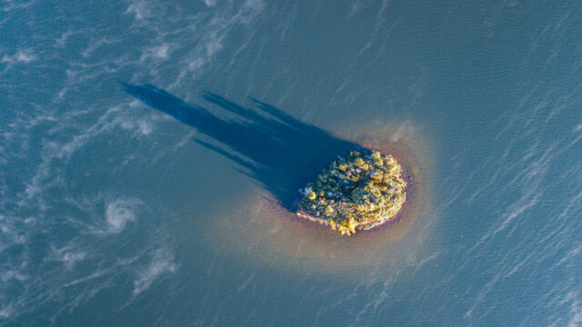 Inselchen am Morgen mit langem Schatten und Nebelschwaden