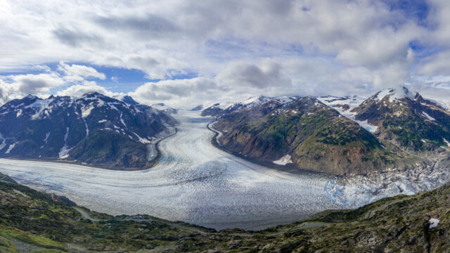 Der Gletscher fliesst von der Mitte runter und verzweigt dann nach links und rechts; Panoramabild mit der Drohne