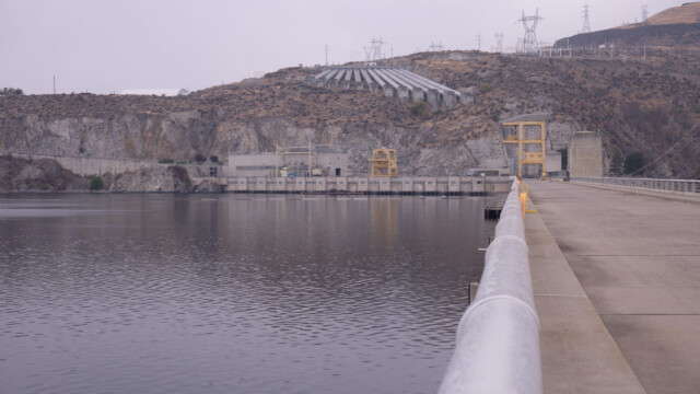 auf der Staumauer, im Hintergrund die Wasser-Leitungen, die das Wasser hoch bringen