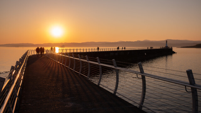 Sonnenuntergang an der langen Hafenmole, die Berge gehören schon zur USA