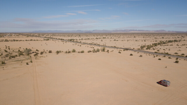 Jupi ganz klein in dem vielen Sand; rechts die Eisenbahnlinie