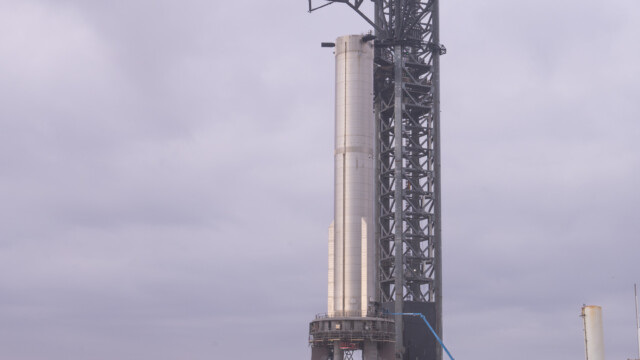 Jupi vor dem Startturm, auf dem der Booster, die erste Stufe des Starship steht